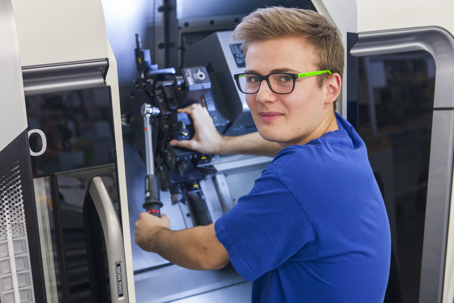 Lernende Polymechaniker drehen und fräsen auf modernen CNC-Maschinen